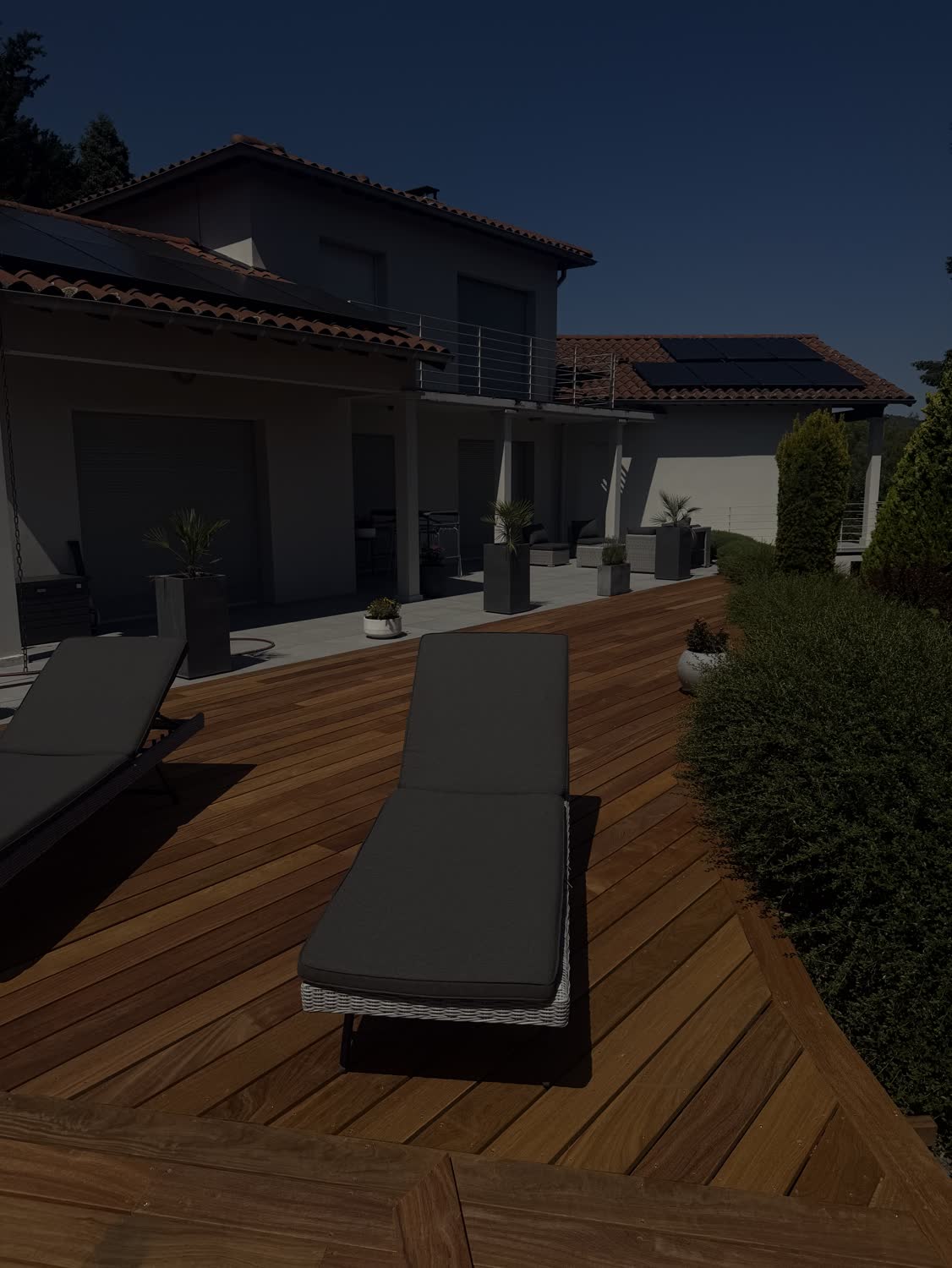 Terrasse en bois autour d'une piscine avec transats